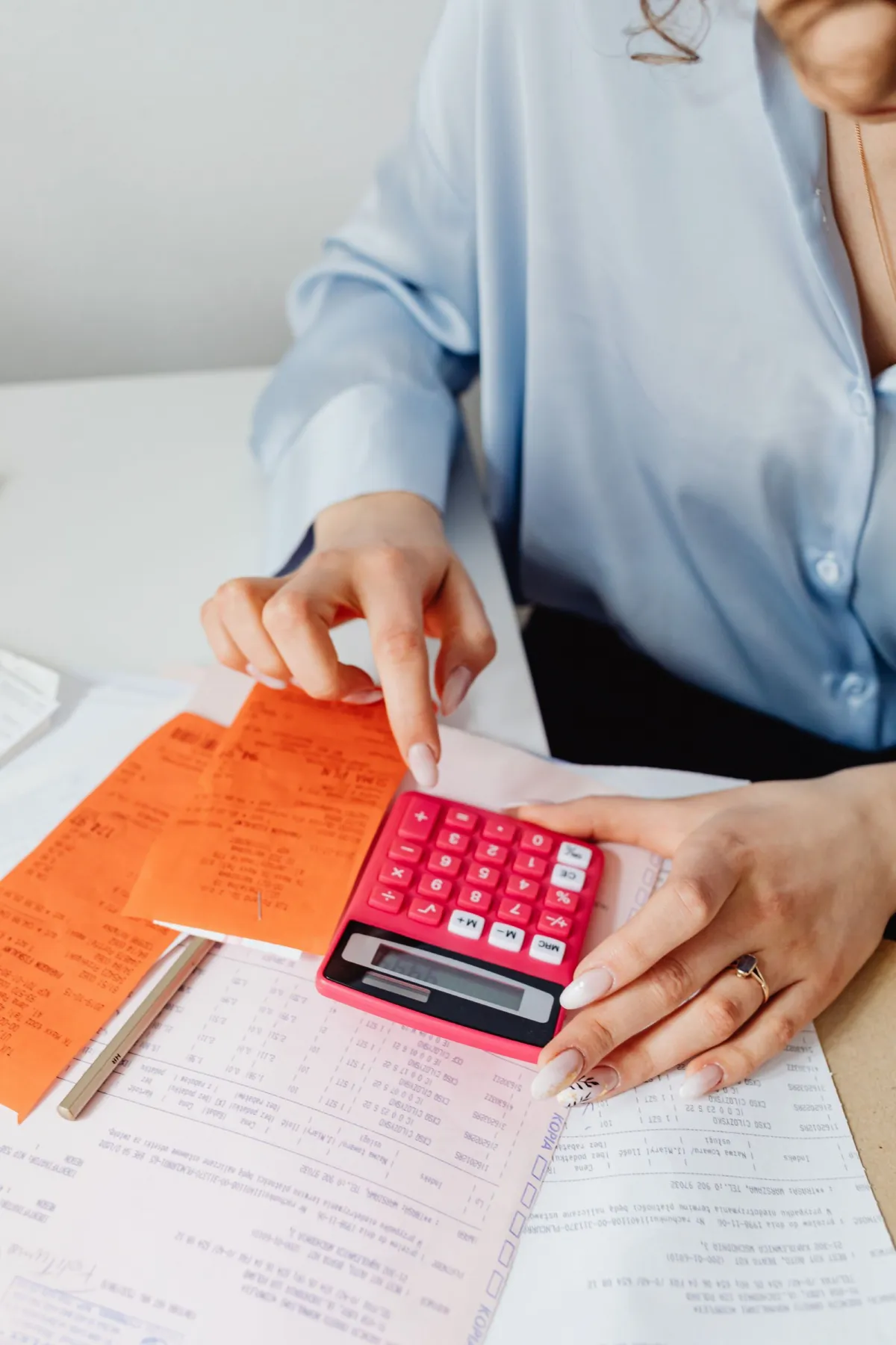 Business owner working through statements and receipts with a calculator