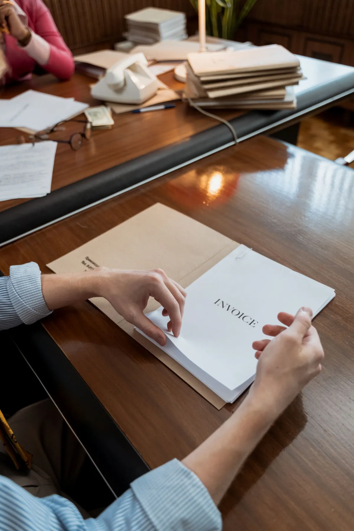 Business person holding a stack of unpaid invoice documents