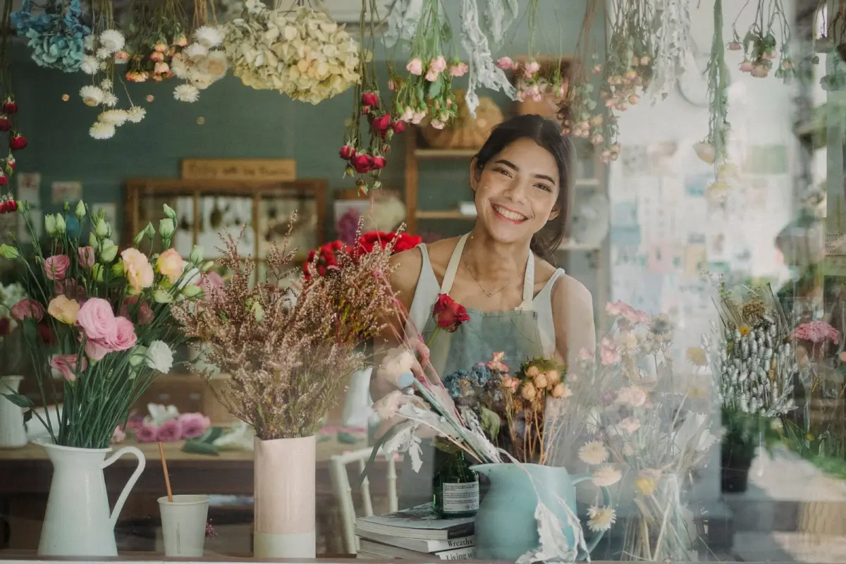 Florist smiling behind the counter of her shop
