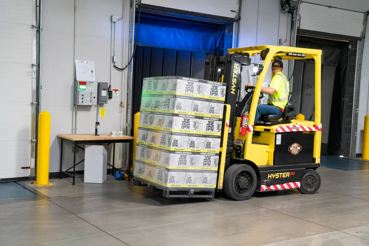 Warehouse worker moving a pallet of stock with a forklift