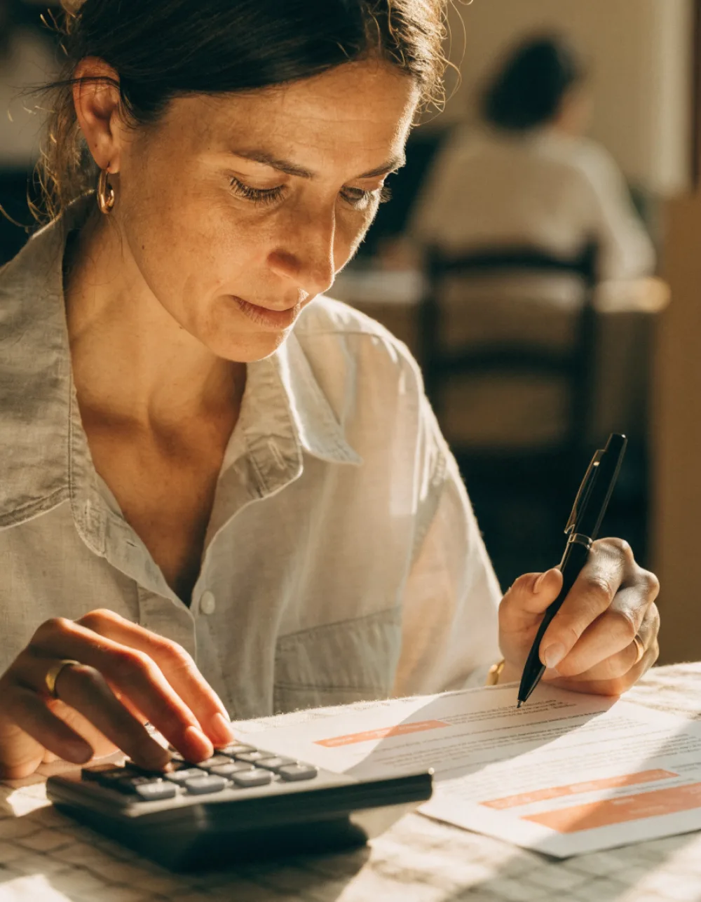Business owner reviewing a finance offer with a calculator, comparing the numbers